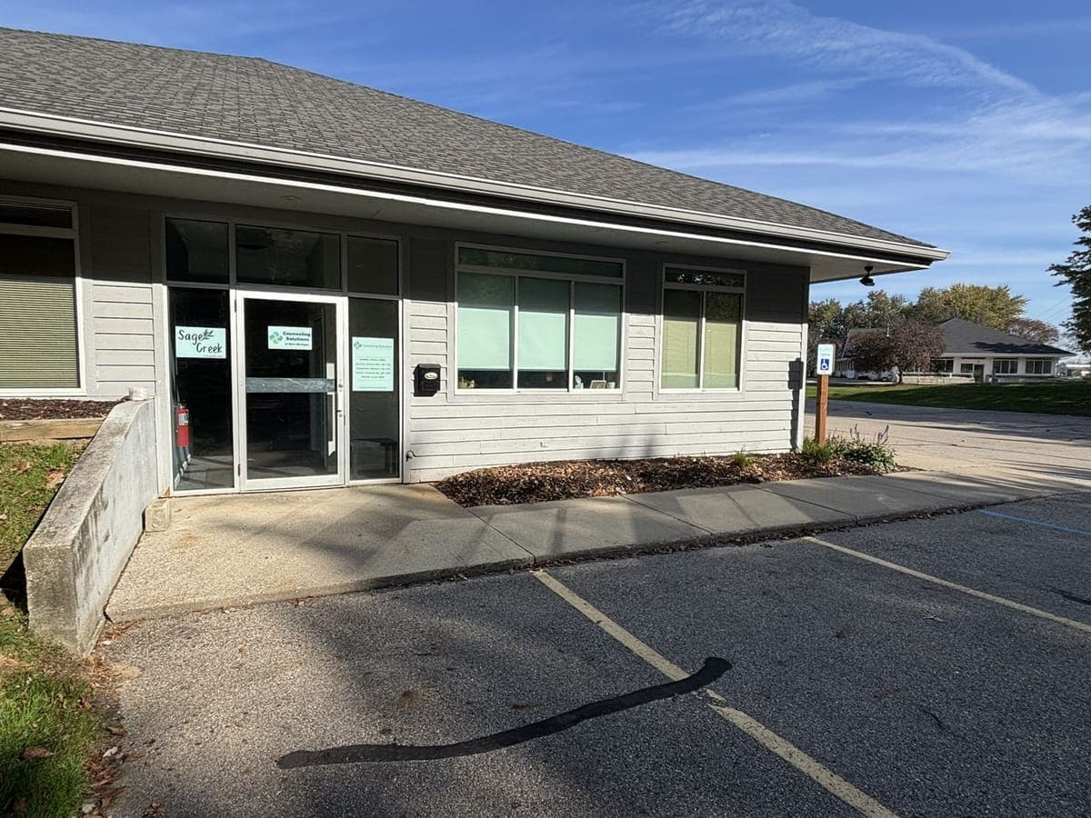 The entrance at the South end, with a reserved accessible parking sign beside the walkway and parking spaces right in front of the door.